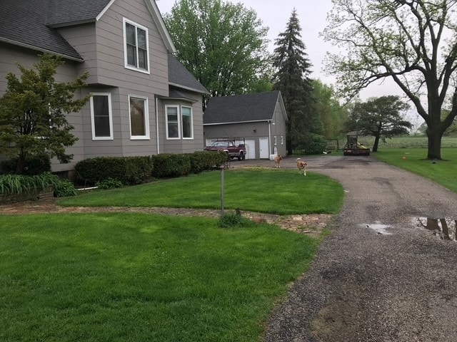 view of side of property with an outbuilding, a yard, and a garage