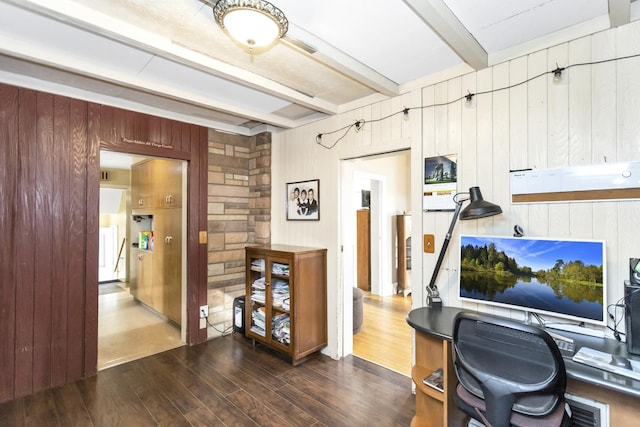 office space featuring wooden walls, dark hardwood / wood-style floors, and beamed ceiling