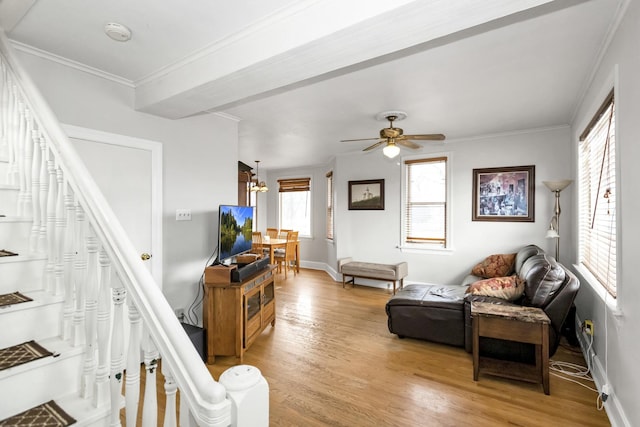 living room featuring ornamental molding, ceiling fan with notable chandelier, and light hardwood / wood-style flooring