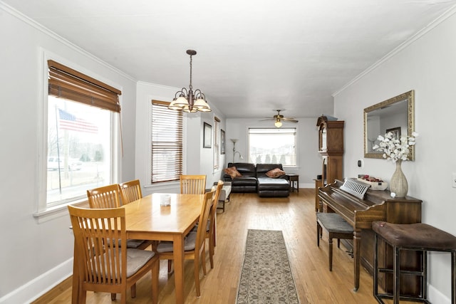 dining space featuring ceiling fan with notable chandelier, ornamental molding, and light hardwood / wood-style floors