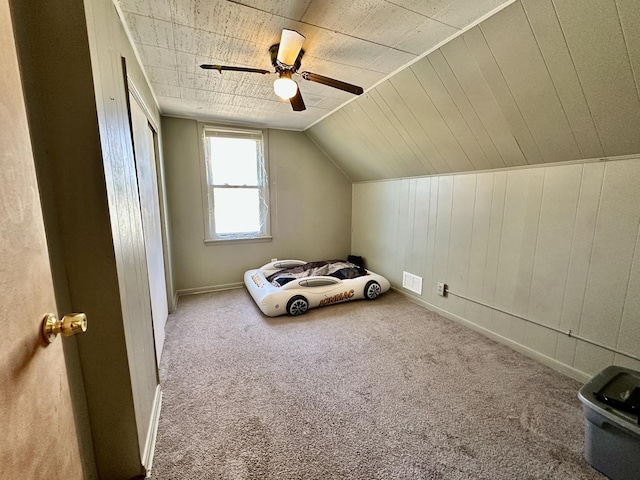 unfurnished bedroom featuring lofted ceiling, carpet flooring, ceiling fan, and a closet