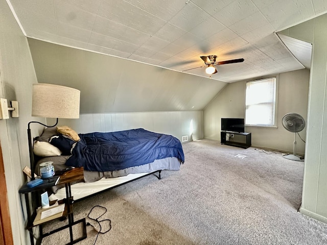 carpeted bedroom with ceiling fan and vaulted ceiling