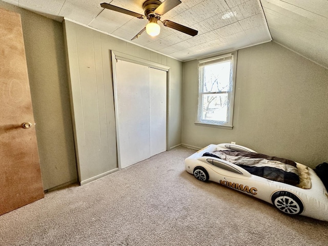 bedroom featuring ceiling fan, lofted ceiling, carpet floors, and a closet