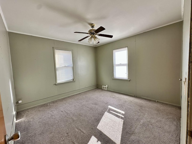 carpeted spare room featuring crown molding and ceiling fan