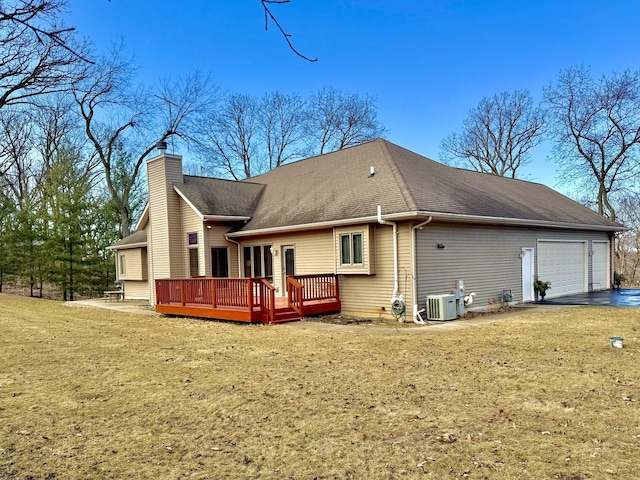 rear view of house with a wooden deck, a garage, a lawn, and central air condition unit