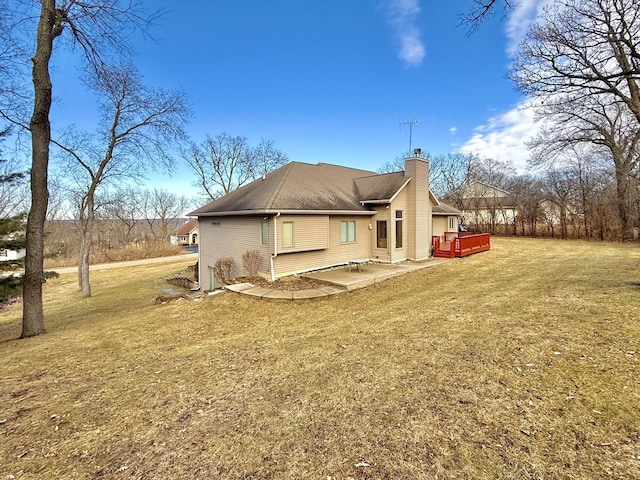 rear view of house with a wooden deck, a yard, and a patio