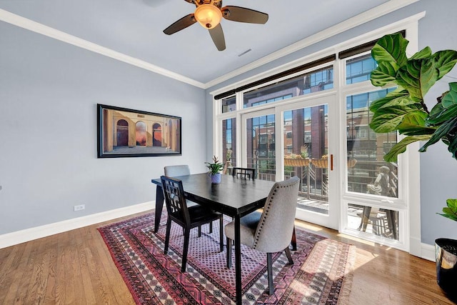 dining space with crown molding, ceiling fan, and wood-type flooring