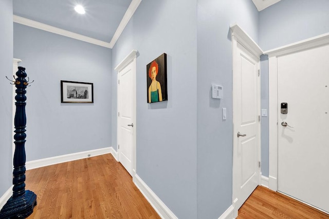 hallway featuring ornamental molding and hardwood / wood-style floors