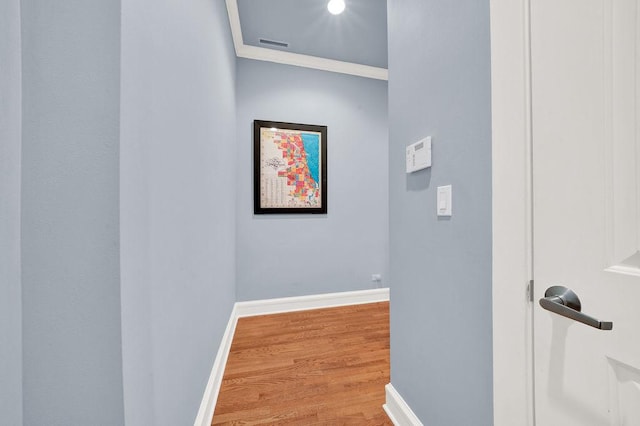 corridor featuring hardwood / wood-style flooring and ornamental molding