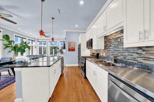 kitchen featuring stainless steel appliances, white cabinetry, and sink