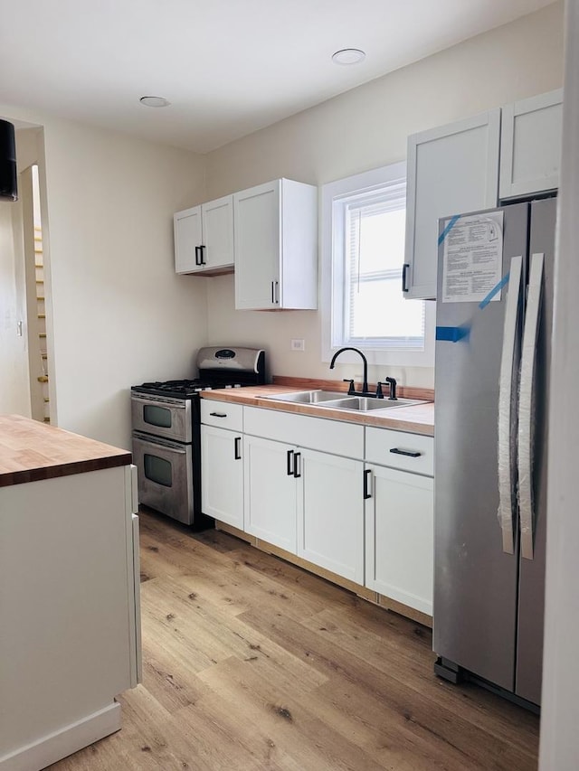 kitchen with white cabinetry, appliances with stainless steel finishes, and sink