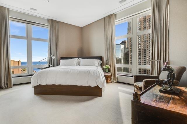 carpeted bedroom featuring a baseboard heating unit and a water view