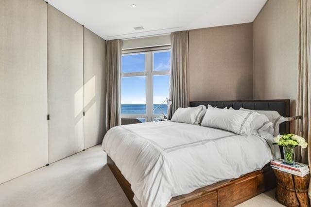 carpeted bedroom featuring a water view