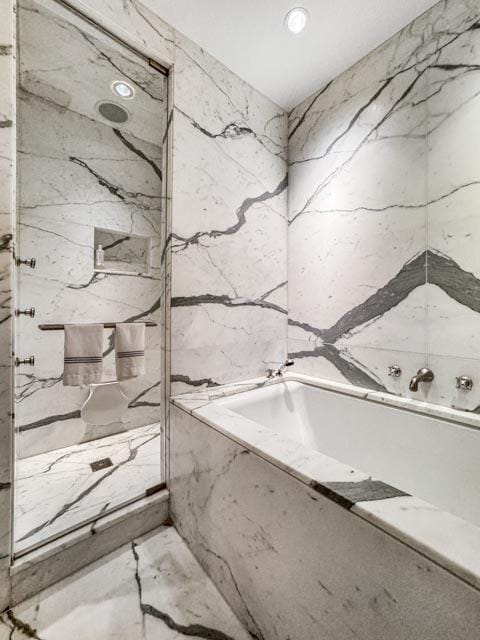 bathroom featuring a relaxing tiled tub