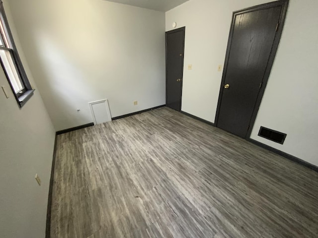 unfurnished room featuring dark wood-type flooring