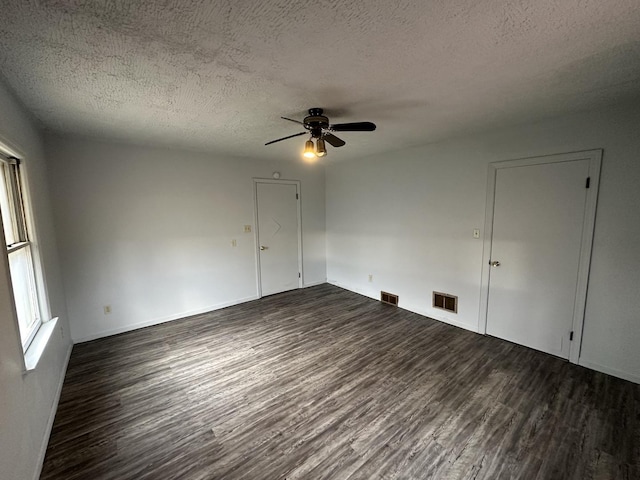 spare room featuring ceiling fan, dark hardwood / wood-style flooring, and a textured ceiling