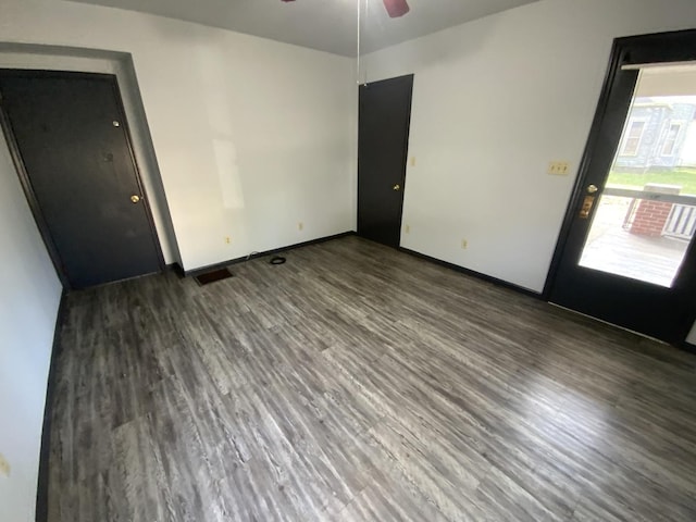 empty room with dark wood-type flooring and ceiling fan