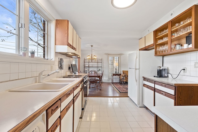 kitchen with hanging light fixtures, plenty of natural light, sink, and backsplash