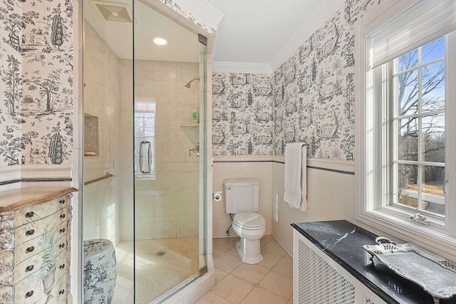 bathroom with tile patterned flooring, ornamental molding, a shower with shower door, and toilet