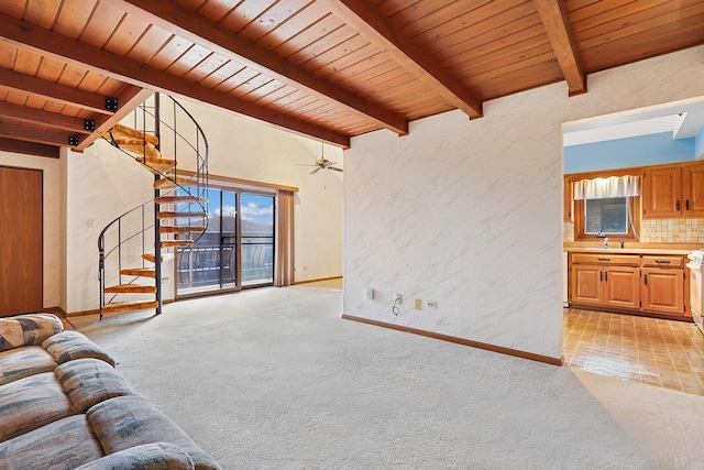 unfurnished living room with sink, wood ceiling, light carpet, ceiling fan, and beam ceiling