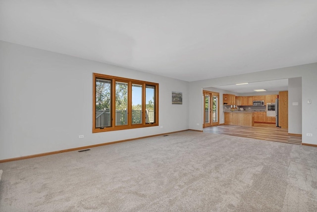 unfurnished living room featuring light carpet