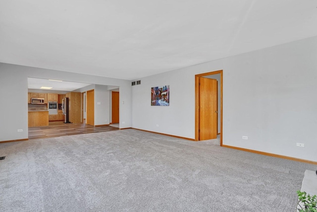 unfurnished living room with light colored carpet