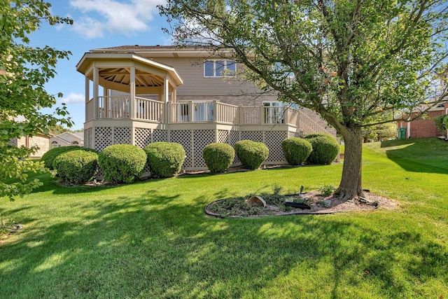 rear view of house featuring a wooden deck and a lawn