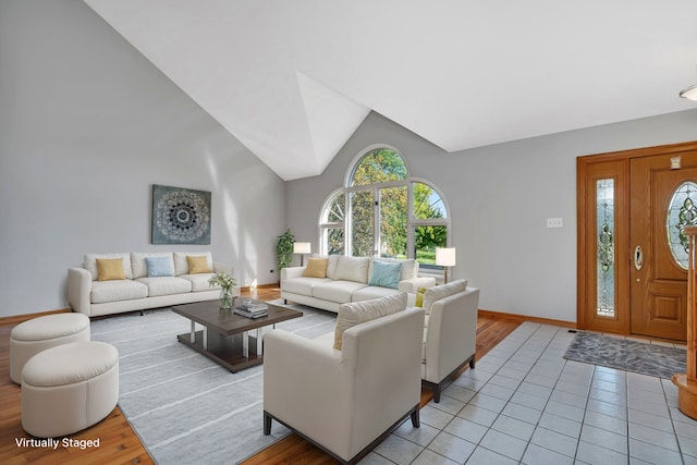 tiled living room featuring plenty of natural light and high vaulted ceiling