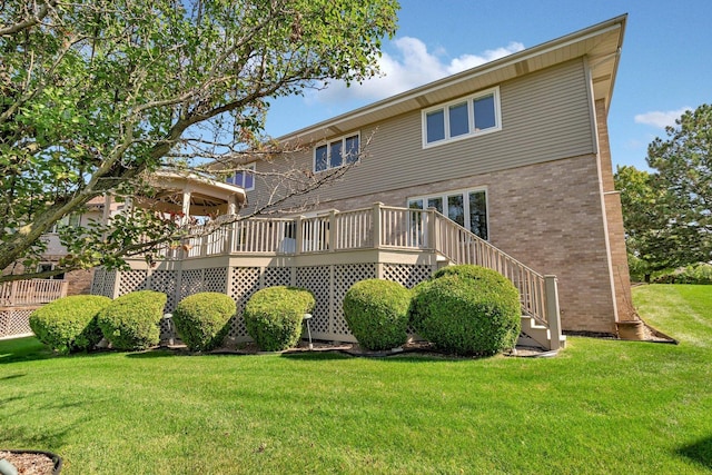 back of house with a wooden deck and a yard