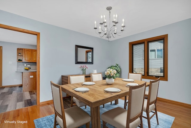 dining room with an inviting chandelier and light hardwood / wood-style flooring