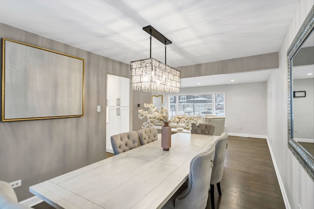 dining space with an inviting chandelier and dark hardwood / wood-style flooring