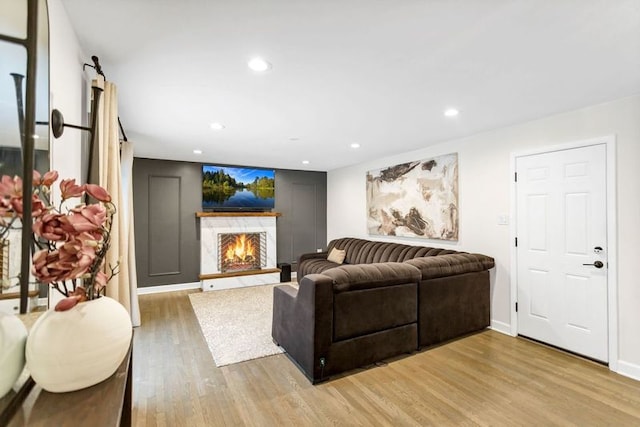 living room featuring a premium fireplace and light hardwood / wood-style floors