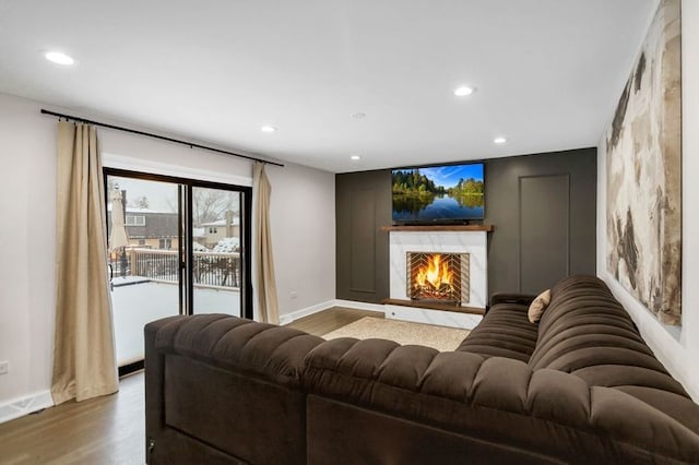 living room with hardwood / wood-style flooring and a high end fireplace