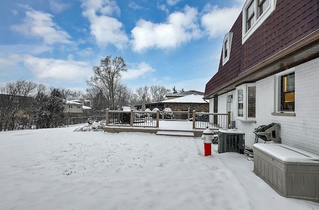 yard covered in snow with a wooden deck and central AC