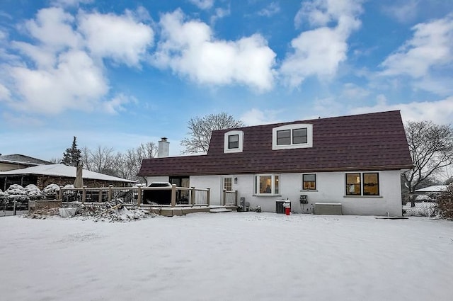 view of snow covered rear of property