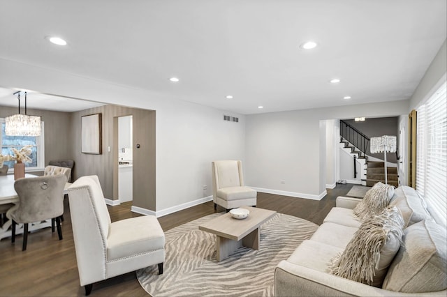 living room featuring dark hardwood / wood-style flooring and an inviting chandelier