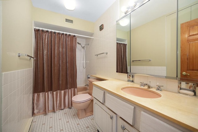 full bathroom featuring tile patterned floors, toilet, shower / tub combo, tile walls, and vanity