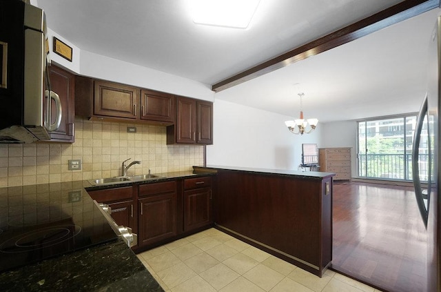 kitchen featuring sink, decorative backsplash, hanging light fixtures, kitchen peninsula, and beam ceiling