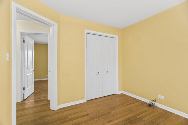 unfurnished bedroom featuring wood-type flooring and a closet