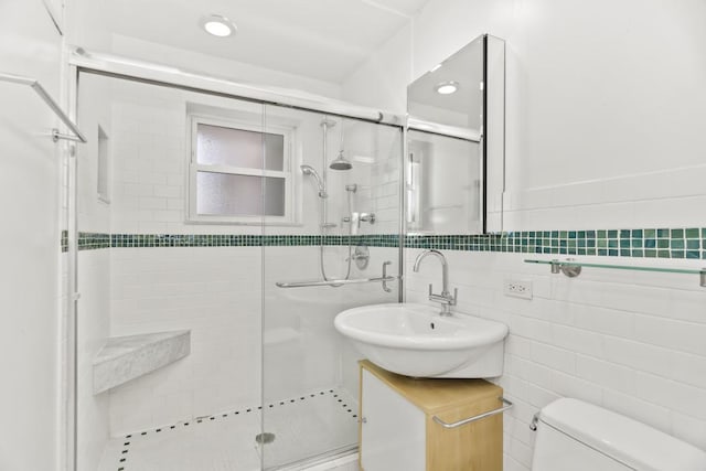 bathroom with toilet, tile walls, vanity, and walk in shower