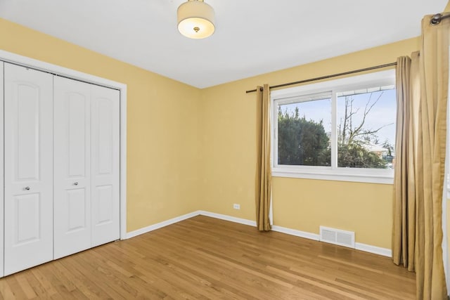 unfurnished bedroom featuring a closet and light wood-type flooring