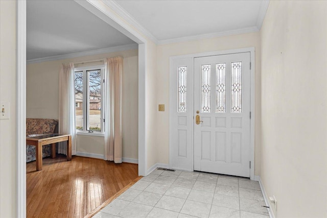 entrance foyer featuring ornamental molding and light hardwood / wood-style floors