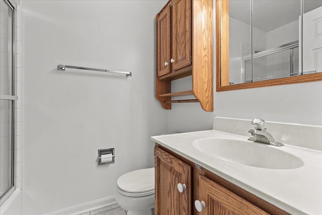 bathroom with vanity, toilet, and a shower with shower door