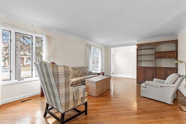 living room featuring ornamental molding and light hardwood / wood-style flooring