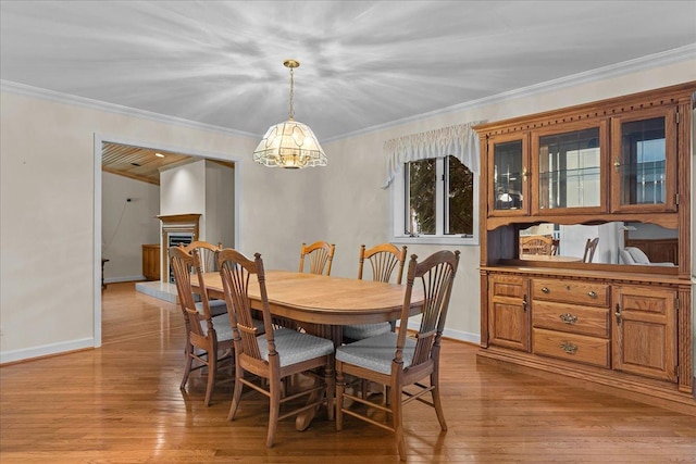 dining space with ornamental molding and light hardwood / wood-style floors