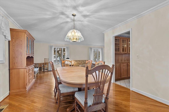 dining room with a notable chandelier, light hardwood / wood-style flooring, and ornamental molding