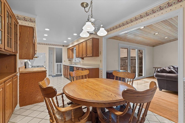 dining area featuring crown molding, light tile patterned flooring, and a chandelier