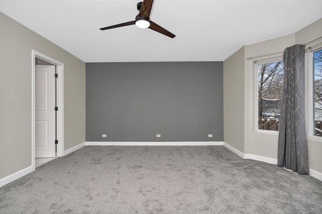 carpeted spare room featuring ceiling fan