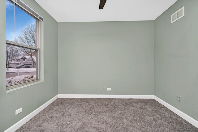 empty room featuring ceiling fan and carpet