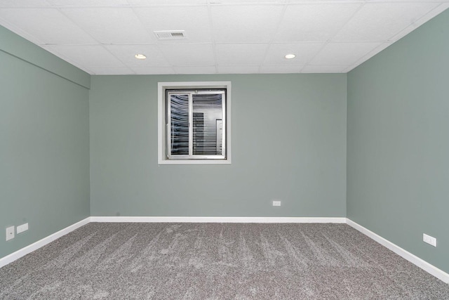 empty room with carpet flooring and a paneled ceiling